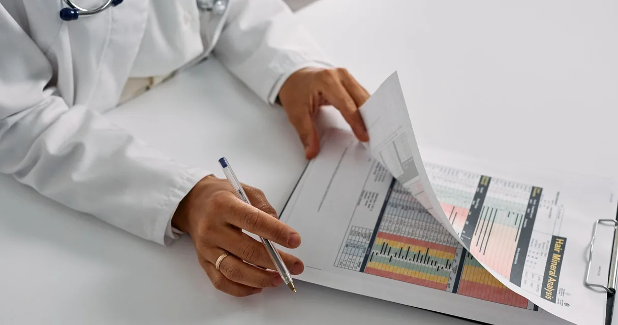 Médico de jaleco analisando exames em uma pasta sobre a mesa, dados sobre as doenças mais comuns