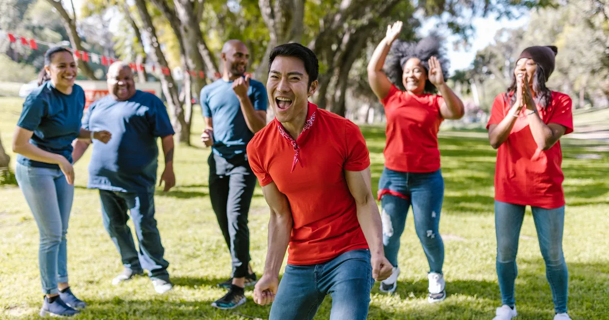 Grupo de pessoas rindo em uma dinâmica ao ar livre no parque, atividades para dependentes químicos