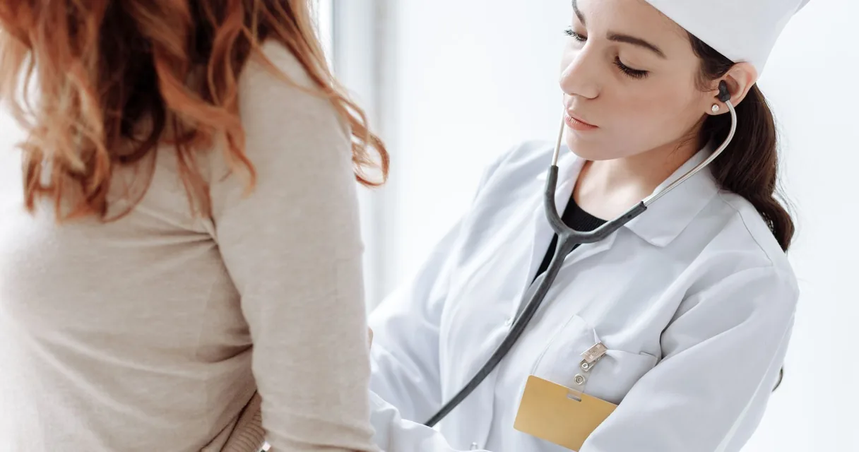 Médica auscultando uma paciente com estetoscópio em consultório, diagnóstico das doenças mais comuns