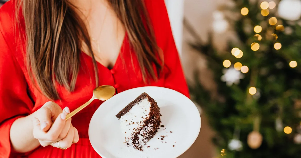 Mulher segurando um prato com fatia de bolo de chocolate, vício em açúcar e vontade de comer doce